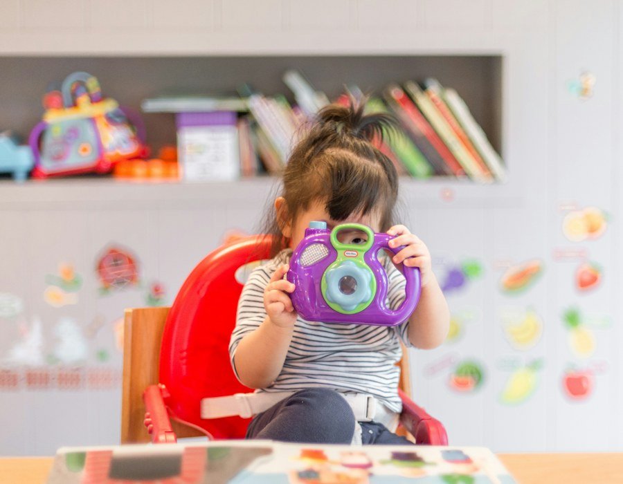 A child playing at home with a toy camera